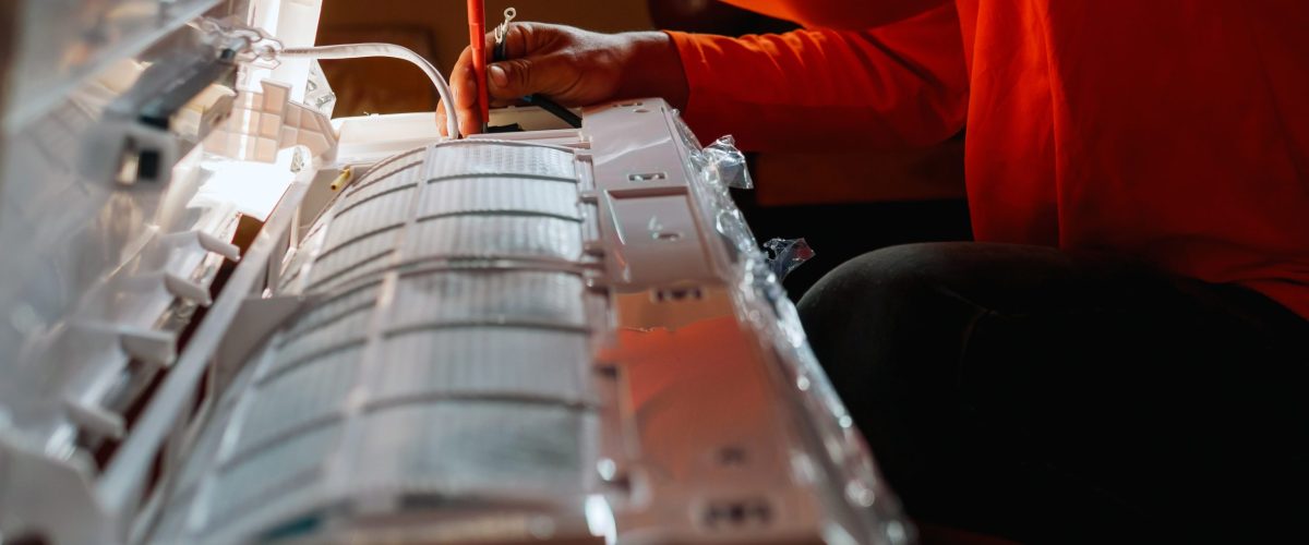 Hand of technician use a screwdriver to tighten the air conditioning assembly nuts, Air conditioning technicians Prepare to  install new air conditioner in homes.