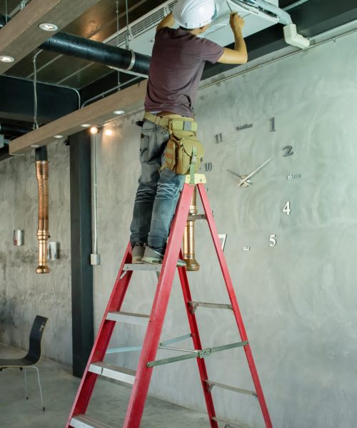 Service man technician repairing air conditioner on the ceiling
